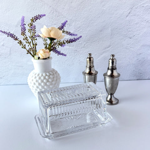 Vintage clear glass butter dish with raised “Beurre” lettering visible through the lid and ribbed radiating base.