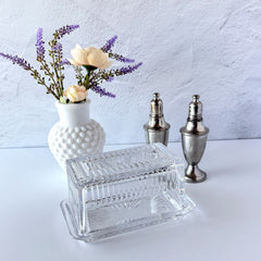 Vintage clear glass butter dish with raised “Beurre” lettering visible through the lid and ribbed radiating base.