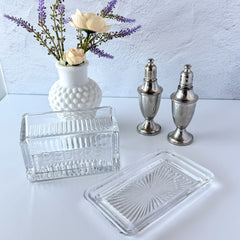 Vintage clear glass butter dish with raised “Beurre” lettering visible through the lid and ribbed radiating base.