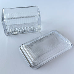 Vintage clear glass butter dish with raised “Beurre” lettering visible through the lid and ribbed radiating base.
