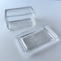 Vintage clear glass butter dish with raised “Beurre” lettering visible through the lid and ribbed radiating base.