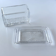 Vintage clear glass butter dish with raised “Beurre” lettering visible through the lid and ribbed radiating base.