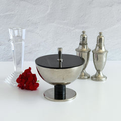 Vintage signed Igi nickel‑plated brass and black plastic modernist candy dish with lid, shown from multiple angles including signature underside.