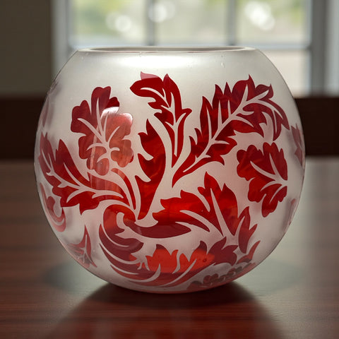 Vintage Illuminations frosted glass candle holder with etched red Spanish lace leaf pattern, rose bowl shape, softly glowing surface ideal for holiday decor or cozy ambiance.