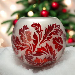 Vintage Illuminations frosted glass candle holder with etched red Spanish lace leaf pattern, rose bowl shape, softly glowing surface ideal for holiday decor or cozy ambiance.