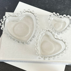 Vintage Imperial clear glass Candlewick heart-shaped dishes in a set of three, shown in various arrangements for decorative or serving use.