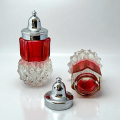 Pair of vintage Indiana Glass salt and pepper shakers featuring clear diamond point bases, paneled ruby red flash bands, and chrome-plated screw-on lids marked Made in Hong Kong. Mid-century design in excellent vintage condition.