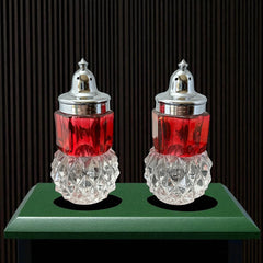 Pair of vintage Indiana Glass salt and pepper shakers featuring clear diamond point bases, paneled ruby red flash bands, and chrome-plated screw-on lids marked Made in Hong Kong. Mid-century design in excellent vintage condition.