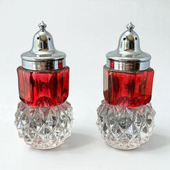 Pair of vintage Indiana Glass salt and pepper shakers featuring clear diamond point bases, paneled ruby red flash bands, and chrome-plated screw-on lids marked Made in Hong Kong. Mid-century design in excellent vintage condition.