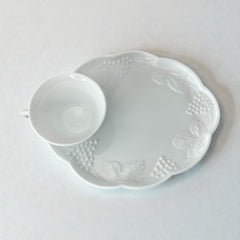  Vintage Indiana Glass Colony Harvest Grape milk glass snack plate and cup set from the 1960s, featuring embossed grapevine motifs and glossy white finish.
