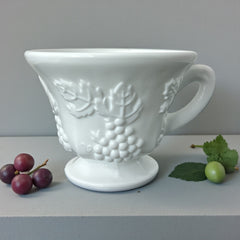  Vintage Indiana Glass Colony Harvest Grape milk glass snack plate and cup set from the 1960s, featuring embossed grapevine motifs and glossy white finish.
