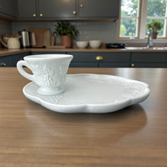  Vintage Indiana Glass Colony Harvest Grape milk glass snack plate and cup set from the 1960s, featuring embossed grapevine motifs and glossy white finish.
