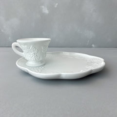  Vintage Indiana Glass Colony Harvest Grape milk glass snack plate and cup set from the 1960s, featuring embossed grapevine motifs and glossy white finish.
