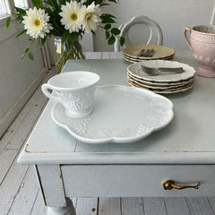  Vintage Indiana Glass Colony Harvest Grape milk glass snack plate and cup set from the 1960s, featuring embossed grapevine motifs and glossy white finish.
