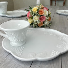  Vintage Indiana Glass Colony Harvest Grape milk glass snack plate and cup set from the 1960s, featuring embossed grapevine motifs and glossy white finish.
