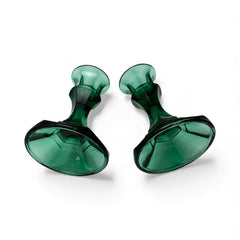 Pair of vintage Indiana Glass green candlestick holders with hexagonal bases, shown on a white surface. The emerald green glass catches the light, highlighting their faceted mid-century design and tapered silhouette. Ideal for holiday styling or eco-conscious vintage decor.