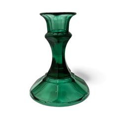 Pair of vintage Indiana Glass green candlestick holders with hexagonal bases, shown on a white surface. The emerald green glass catches the light, highlighting their faceted mid-century design and tapered silhouette. Ideal for holiday styling or eco-conscious vintage decor.