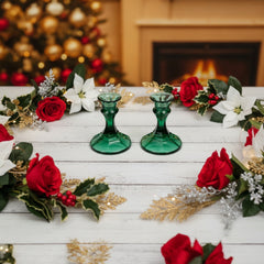 Pair of vintage Indiana Glass green candlestick holders with hexagonal bases, shown on a white surface. The emerald green glass catches the light, highlighting their faceted mid-century design and tapered silhouette. Ideal for holiday styling or eco-conscious vintage decor.