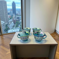 Set of four vintage Indiana Glass punch or tea cups in Princess Blue Harvest Grape pattern, made in the early 1970s; iridescent blue glass with embossed grape and leaf motifs, each cup approx. 2⅜" tall and 3⅜" in diameter, with 4¼" width including handle; excellent vintage condition with vibrant multicolor sheen.