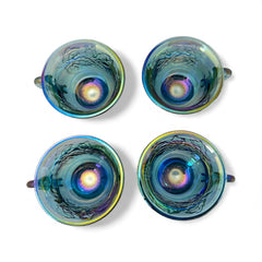 Set of four vintage Indiana Glass punch or tea cups in Princess Blue Harvest Grape pattern, made in the early 1970s; iridescent blue glass with embossed grape and leaf motifs, each cup approx. 2⅜" tall and 3⅜" in diameter, with 4¼" width including handle; excellent vintage condition with vibrant multicolor sheen.