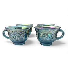 Set of four vintage Indiana Glass punch or tea cups in Princess Blue Harvest Grape pattern, made in the early 1970s; iridescent blue glass with embossed grape and leaf motifs, each cup approx. 2⅜" tall and 3⅜" in diameter, with 4¼" width including handle; excellent vintage condition with vibrant multicolor sheen.