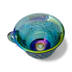 Set of four vintage Indiana Glass punch or tea cups in Princess Blue Harvest Grape pattern, made in the early 1970s; iridescent blue glass with embossed grape and leaf motifs, each cup approx. 2⅜" tall and 3⅜" in diameter, with 4¼" width including handle; excellent vintage condition with vibrant multicolor sheen.