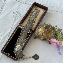 Vintage Italian Rome souvenir coin bracelet with silver‑tone medals of Colosseum, San Pietro, and she‑wolf, adjustable length.