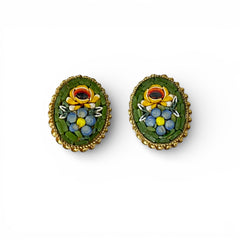 Vintage oval Italian micro‑mosaic clip‑on earrings with yellow and blue floral designs on a green background, framed in a gold‑tone twisted rope border. The mosaic is intact and detailed, with light wear visible on the backs.