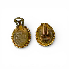 Vintage oval Italian micro‑mosaic clip‑on earrings with yellow and blue floral designs on a green background, framed in a gold‑tone twisted rope border. The mosaic is intact and detailed, with light wear visible on the backs.