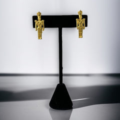 Gold tone vintage nutcracker earrings by JJ, featuring detailed toy soldier figures with tall hats and crossed arms; signed on the back with copyright symbol.