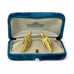 Gold tone vintage nutcracker earrings by JJ, featuring detailed toy soldier figures with tall hats and crossed arms; signed on the back with copyright symbol.