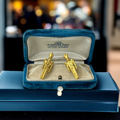 Gold tone vintage nutcracker earrings by JJ, featuring detailed toy soldier figures with tall hats and crossed arms; signed on the back with copyright symbol.