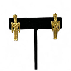Gold tone vintage nutcracker earrings by JJ, featuring detailed toy soldier figures with tall hats and crossed arms; signed on the back with copyright symbol.