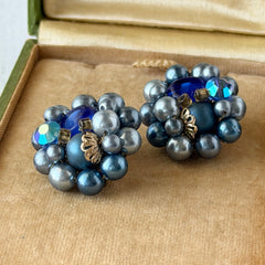Vintage Japan blue faux pearl and rhinestone cluster clip‑on earrings with gold filigree backs, shown from multiple angles to highlight their wired construction and luminous beads.