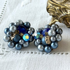 Vintage Japan blue faux pearl and rhinestone cluster clip‑on earrings with gold filigree backs, shown from multiple angles to highlight their wired construction and luminous beads.