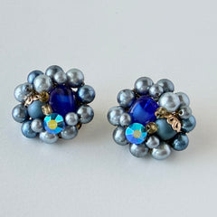 Vintage Japan blue faux pearl and rhinestone cluster clip‑on earrings with gold filigree backs, shown from multiple angles to highlight their wired construction and luminous beads.