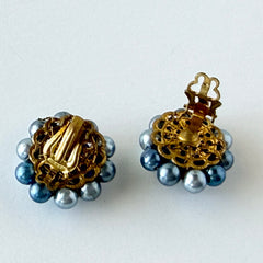 Vintage Japan blue faux pearl and rhinestone cluster clip‑on earrings with gold filigree backs, shown from multiple angles to highlight their wired construction and luminous beads.