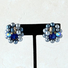 Vintage Japan blue faux pearl and rhinestone cluster clip‑on earrings with gold filigree backs, shown from multiple angles to highlight their wired construction and luminous beads.