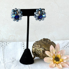 Vintage Japan blue faux pearl and rhinestone cluster clip‑on earrings with gold filigree backs, shown from multiple angles to highlight their wired construction and luminous beads.