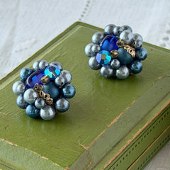 Vintage Japan blue faux pearl and rhinestone cluster clip‑on earrings with gold filigree backs, shown from multiple angles to highlight their wired construction and luminous beads.
