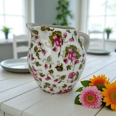 Vintage 1950s Japan porcelain creamer with pink chintz floral pattern, green leaves, and gold trim on rim and handle, marked Made in Japan