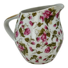 Vintage 1950s Japan porcelain creamer with pink chintz floral pattern, green leaves, and gold trim on rim and handle, marked Made in Japan