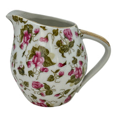 Vintage 1950s Japan porcelain creamer with pink chintz floral pattern, green leaves, and gold trim on rim and handle, marked Made in Japan