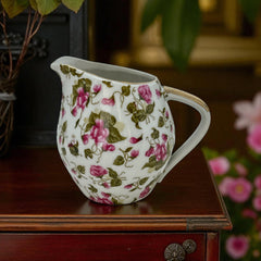 Vintage 1950s Japan porcelain creamer with pink chintz floral pattern, green leaves, and gold trim on rim and handle, marked Made in Japan