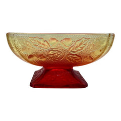 Vintage Jeannette Amberina Depression glass dish from the 1930s featuring a square footed base, an Acorn and Leaf pattern, and a color gradient from amber/yellow to red. Perfect as a candy dish or decorative piece, with a small chip on the rim adding character to its vintage charm.