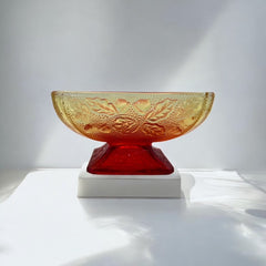 Vintage Jeannette Amberina Depression glass dish from the 1930s featuring a square footed base, an Acorn and Leaf pattern, and a color gradient from amber/yellow to red. Perfect as a candy dish or decorative piece, with a small chip on the rim adding character to its vintage charm.