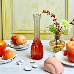 Vintage Jeannette Glass vase with ombre Amberina coloring and fluted design, styled with complementary flowers and soft lighting to highlight its texture, color gradient, and collectible charm.