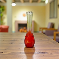 Vintage Jeannette Glass vase with ombre Amberina coloring and fluted design, styled with complementary flowers and soft lighting to highlight its texture, color gradient, and collectible charm.