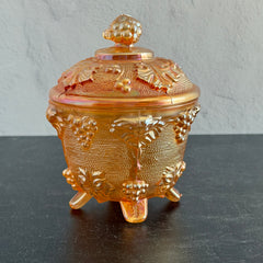 Vintage Jeannette marigold carnival glass candy dish with grape and leaf pattern, iridescent finish, and footed base