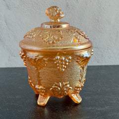 Vintage Jeannette marigold carnival glass candy dish with grape and leaf pattern, iridescent finish, and footed base